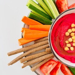Beet Hummus Dip with Chickpeas on Top and Vegetables on Plate