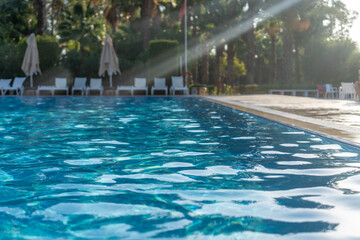 Swimming pool area with sun loungers in the sun, soft focus, tourism background