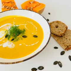 Pumpkin Soup with Coconut Cream in Bowl with Toast