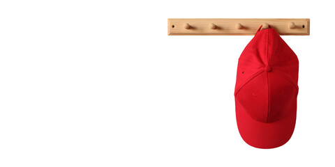 red baseball cap hangs on a wooden clothes rack, isolated on a white background and a copy space.