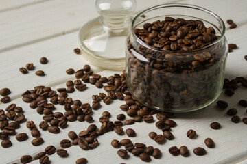 Jar with coffee beans on white table