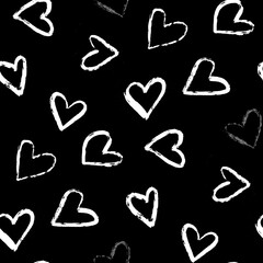 A seamless  pattern of various hand-drawn white hearts tossed on a black background 