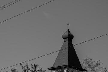 Black and white photo of the church steeple against the blue sky