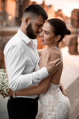 Pair of brides and grooms in love embrace on a blurred background of a river