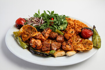 Turkish kebab lamb meat on skewer.
with vegetables and rice on a serving plate