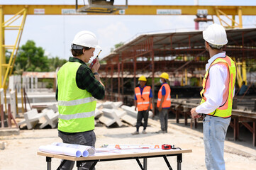Engineers and foremen wearing hard hats in factory. Hard hats talking on construction site.