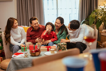 presents, family, enjoying, xmas, present, celebration, christmas, celebrate, christmas eve, gifts. A family of five is sitting around a table with presents and a cake.
