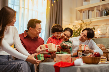presents, parenthood, party, celebrate, present, celebration, christmas, parents, family, xmas. A family of four is sitting around a table with presents. Scene is joyful and festive.