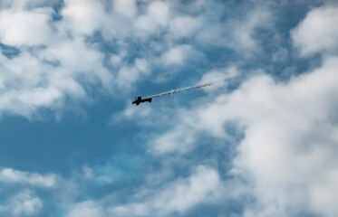 A pilot flies an aerobatic propeller plane in the sky