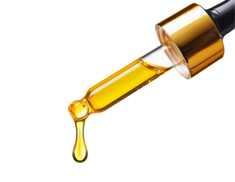 Yellow essential serum oil dripping from gold dropper isolated on white background. Clipping path.