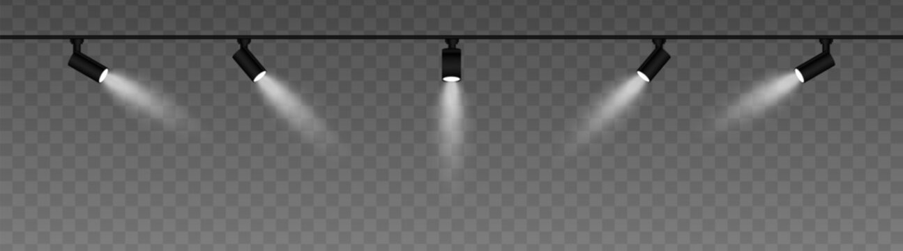 Row of adjustable spotlights with warm white glow, casting angled beams. Modern lighting setup suitable for stage, exhibition, or interior decor, adding ambiance against a dark background