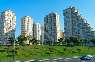 Obraz premium view of the city street and modern residential area with high-rise buildings, green lawn and expressway with cars, urban architecture of Istanbul, Turkey