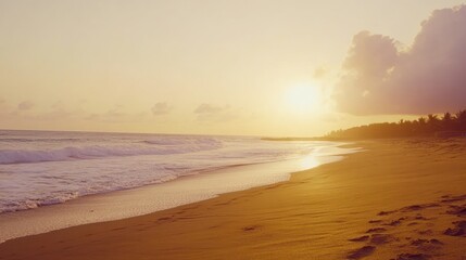 A hazy sunset over a sandy beach with waves crashing on the shore.