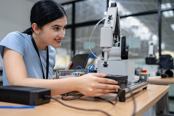 Hispanic engineer woman working on AI technology in robotics electronics engineering laboratory. University students' research project is programming robot machine with intelligent mechanical control