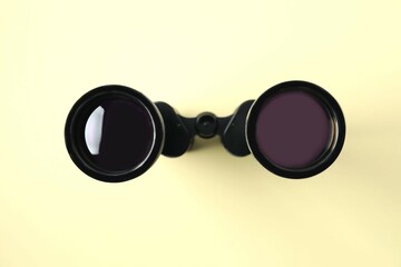 Black binoculars on color background. Top view.