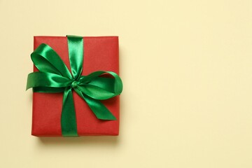 Beautiful gift box tied with bow on color background 