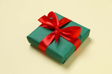 Beautiful gift box tied with bow on color background 