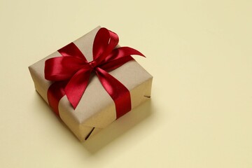Beautiful gift box tied with bow on color background 