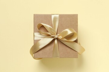 Beautiful gift box tied with bow on color background 