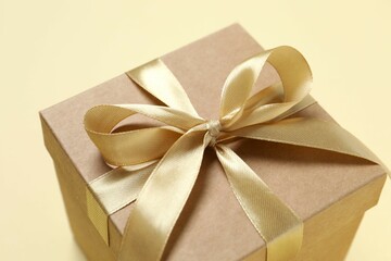 Beautiful gift box tied with bow on color background 