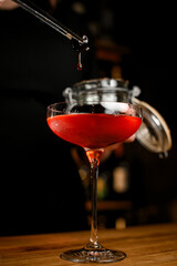Close-up photo of a wine glass filled with a brown cold drink