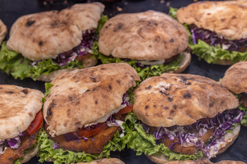 Row of sandwiches with lettuce and meat on them