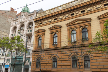 Brown building with a green dome sits next to a white building