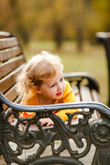 Obraz premium Happy little girl in yellow shirt enjoying autumn nature