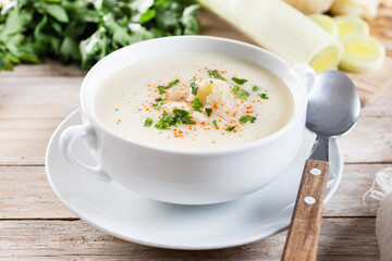 Cauliflower soup in bowl on wooden table