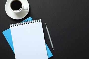 Office table with notebook, stationery and coffee up, top view