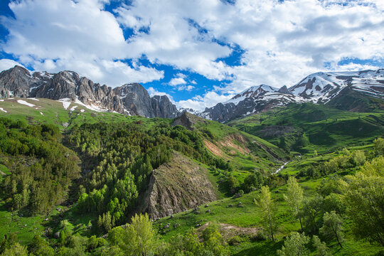 Green plains, snowy mountains. Blue sky and snowy mountains. Snowy mountains of Tunceli. P&uuml;l&uuml;m&uuml;r Valley, Buyer Mountain, Sarıg&uuml;l Plateau, Buyer Waterfall.Munzur, Tunceli, T&uuml;rkiye.
