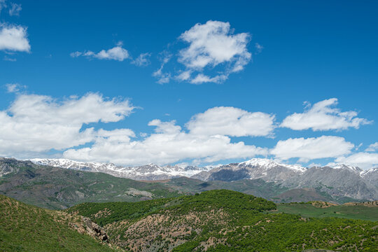 Green plains, snowy mountains. Blue sky and snowy mountains. Snowy mountains of Tunceli. P&uuml;l&uuml;m&uuml;r Valley, Buyer Mountain, Sarıg&uuml;l Plateau, Buyer Waterfall.Munzur, Tunceli, T&uuml;rkiye.
