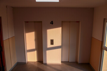 his photo captures a quiet hallway on the fourth floor of a building, featuring two closed elevator doors with the number "4" prominently displayed 