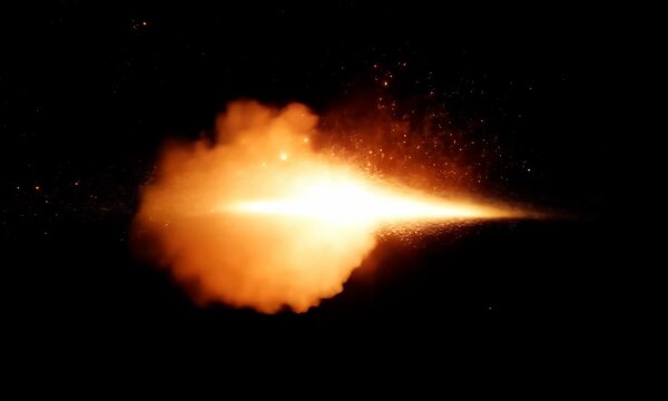 Colliding fireballs exploding into flames on black background