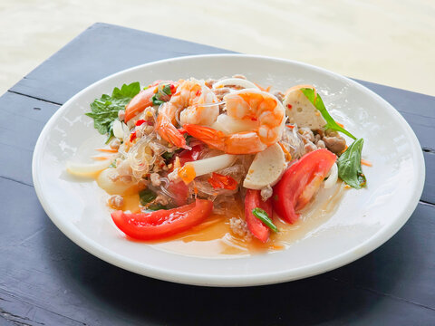 Spicy Glass Noodle Salad, mixed shrimp with minced pork (Thai call Yum Woon Sen) on the table. Side view