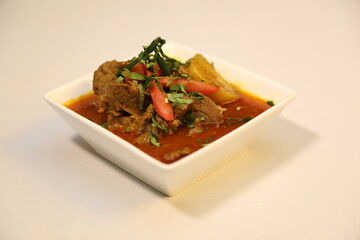 Tender pieces of beef curry with colorful chunks of potato and bell peppers. Decorated with red chili and garnished with fresh coriander leaves.