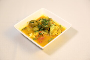 Shutki shira or Olive Sour Curry oriented with fresh herbs. Soured-flavored Bengali curry.