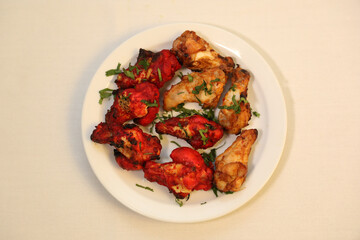 Dry grilled meats showcase marinated chicken with a vibrant red hue, garnished with fresh herbs.