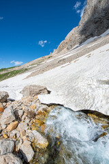 Long exposure river, stream. Glacial valleys and streams. Blue sky and snowy mountains. Snowy mountains of Tunceli. Pülümür Valley, Buyer Mountain, Sarıgül Plateau, Buyer Waterfall. Türkiye.