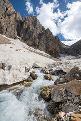 Long exposure river, stream. Glacial valleys and streams. Blue sky and snowy mountains. Snowy mountains of Tunceli. Pülümür Valley, Buyer Mountain, Sarıgül Plateau, Buyer Waterfall. Türkiye.