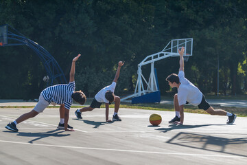 Boys stretches with a coach during basketball training, focusing on flexibility and sports fundamentals. Active coaching and essential warm up for youth basketball players.