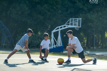 Boys stretches with a coach during basketball training, focusing on flexibility and sports fundamentals. Active coaching and essential warm up for youth basketball players.