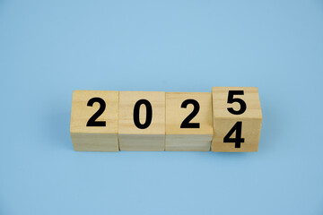 Cubes with numbers 2024 and 2025 on blue background. Flipping of 2024 to 2025.