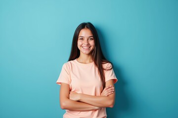 Obraz premium Confident Young Woman Smiling in Casual Pink Shirt Against Blue Background, Perfect for Marketing and Advertising