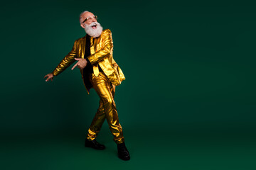 Fototapeta premium Elegant senior man moves against a vibrant green backdrop, embodying retro glamour, perfect for Christmas and New Year parties.