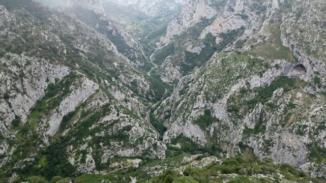 MOUNTAINOUS LANDSCAPE WITH FOG AND WINDING ROAD IN THE LOWER PART LOCATED IN LA ERMIDA