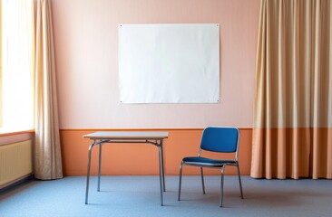 A white blank poster on the wall of an empty room with blue chairs and an orange table. The walls are peach colored, with a curtain on one side. The room is filled with daylight.