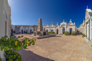 The Cimiteriu Marinu di Bunifaziu near Bonifacio, Corsica, with ornate white tombs and a central monument under a clear sky