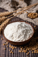 wheat flour and wheat ears on wooden table