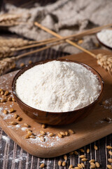 wheat flour and wheat ears on wooden table